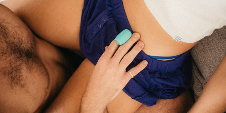 Orgasm Gap: Mann hält Fingervibrator an Hüfte einer Frau in blauen Shorts