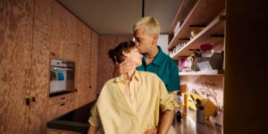 Sexreport 2026: Frau in gelbem Hemd wird von Partner in türkisem Hemd auf die Stirn geküsst