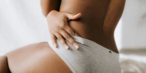 Zyklus und Sex: Frau schlingt Arm um ihren Körper