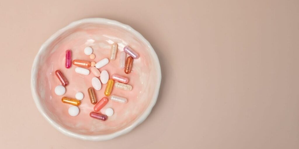 Potenzmittel: Rose Schüsselchen mit verschiedenen pillen und Kapseln