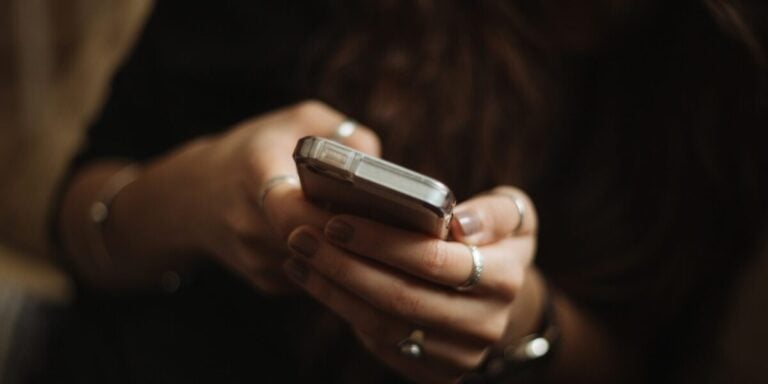 Fehler beim Online-Dating: Hände halten ein Handy