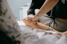 Demisexuell - ein Paar hält Hände im Bett